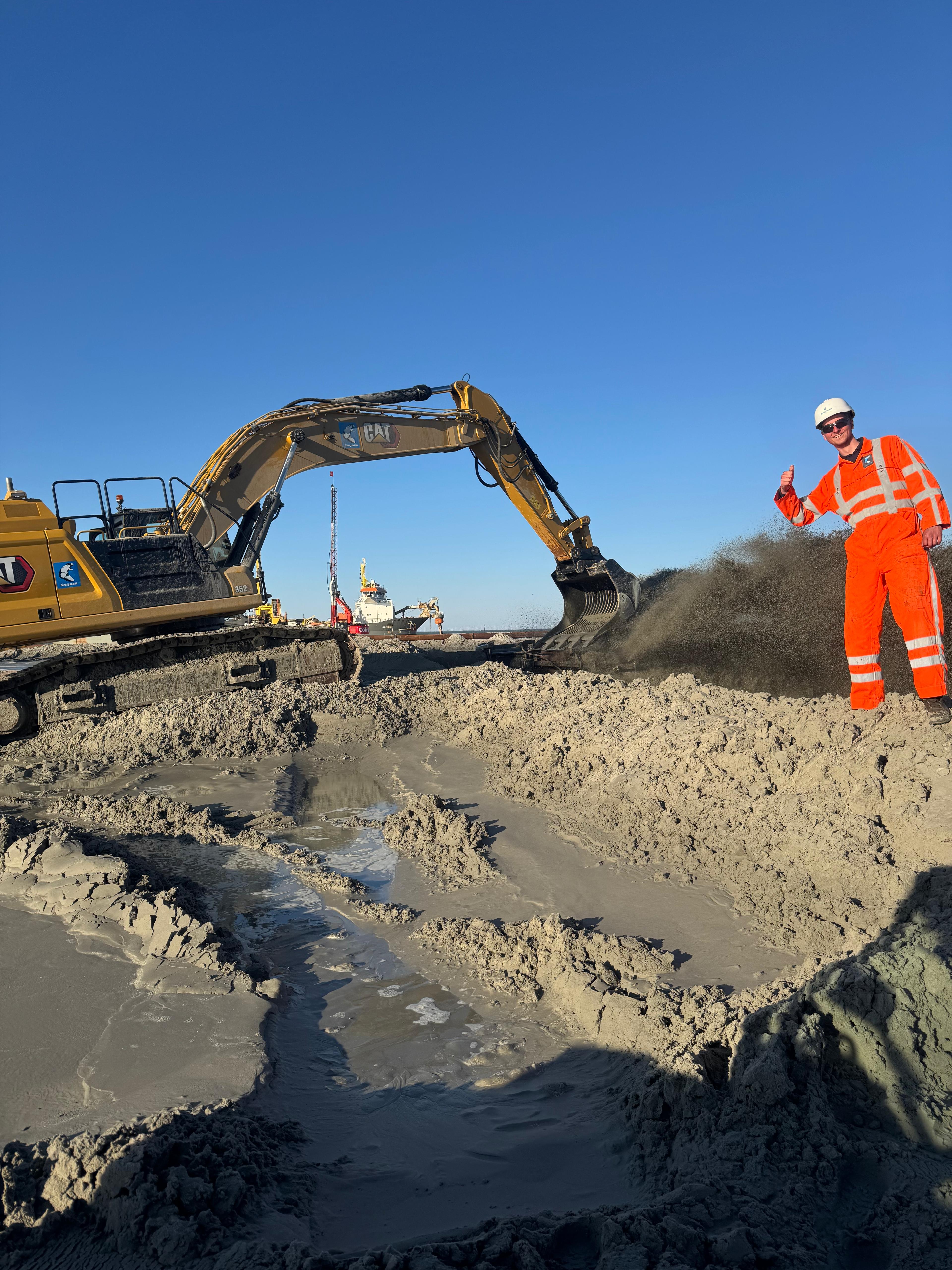 Roan in hi-vis bij machine